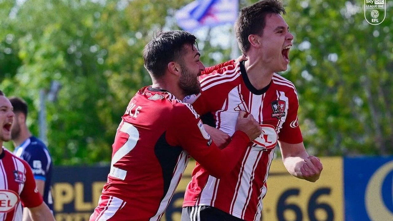 Timur Tutierov celebra un gol con un companero del Exeter City