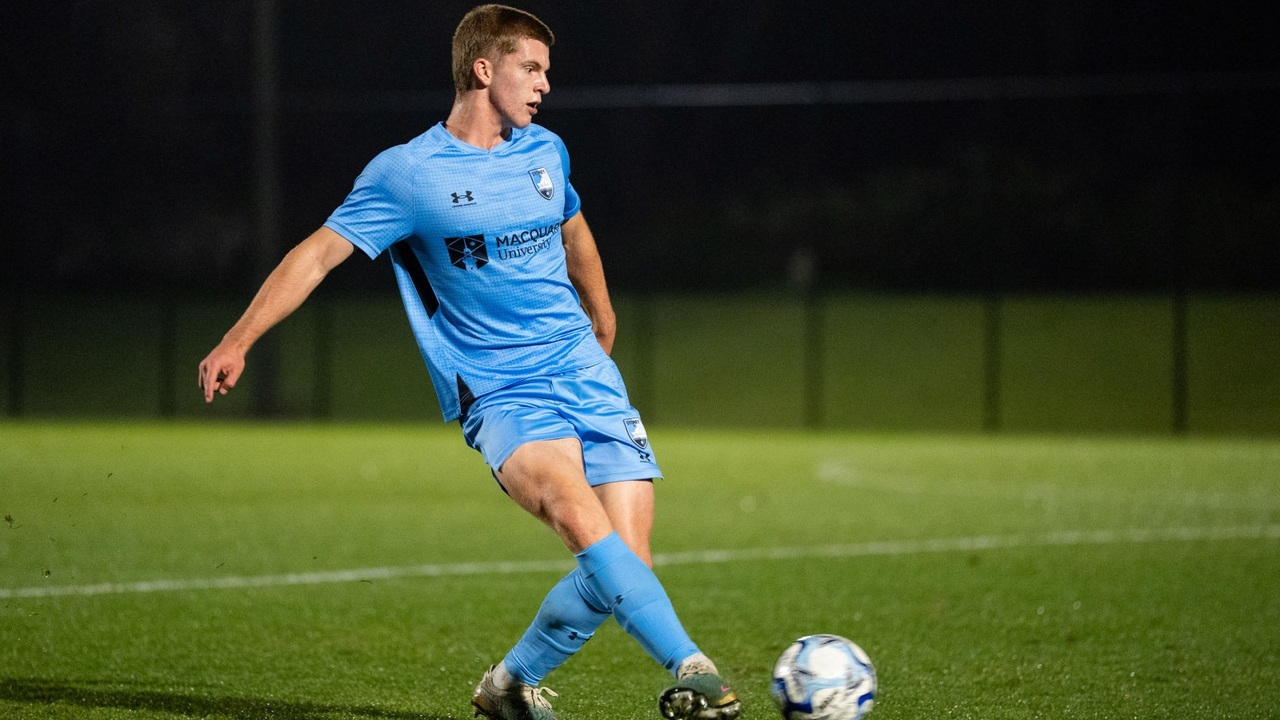 Ethan Dyer vecht om de bal in het shirt van Sydney FC